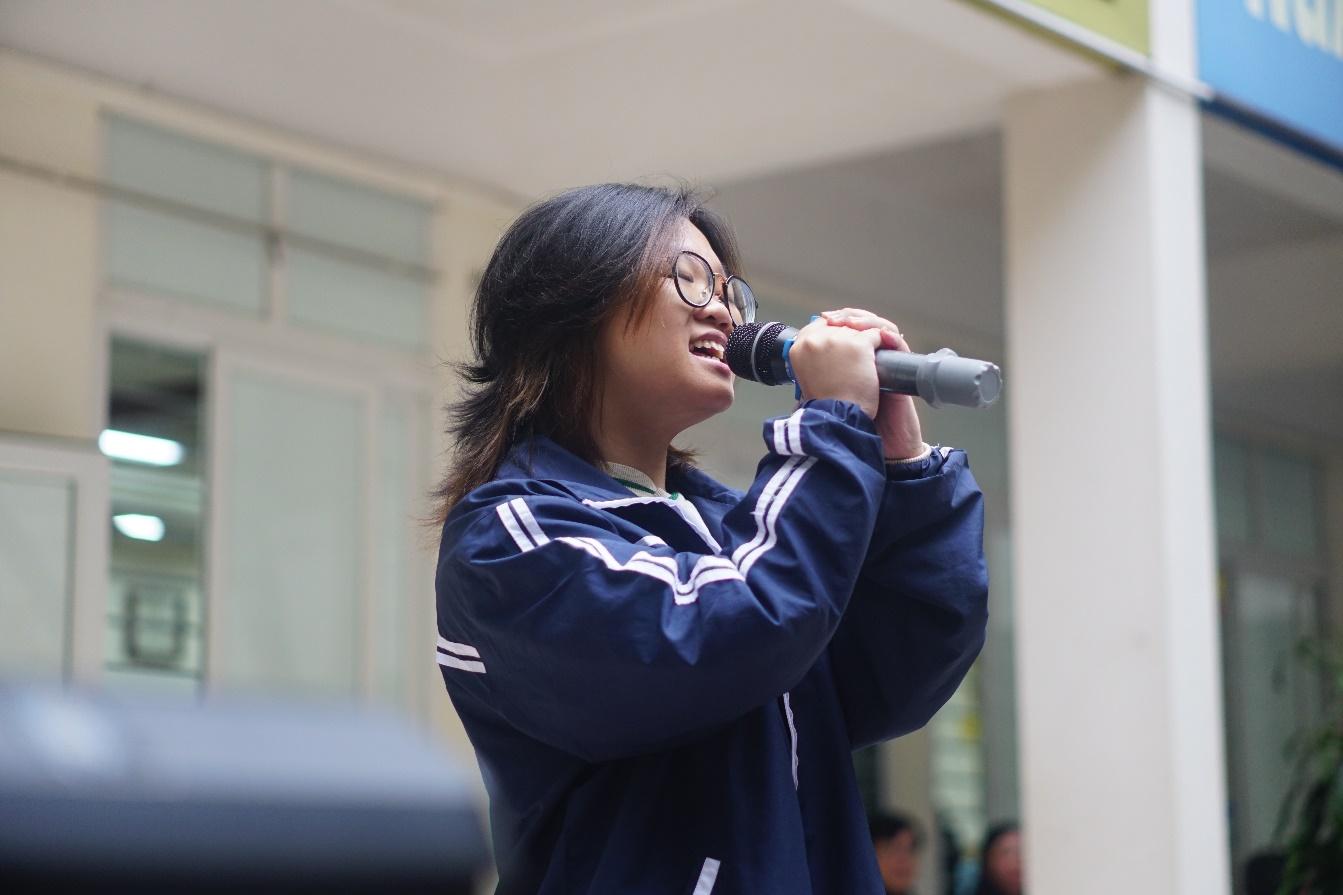 A person singing into a microphone</p>
<p>Description automatically generated